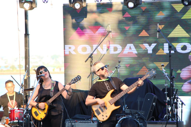 hombre-y-mujer-tocando-guitarra-eléctrica-en-escenario